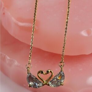 Delicate gold chain with swan pendant.